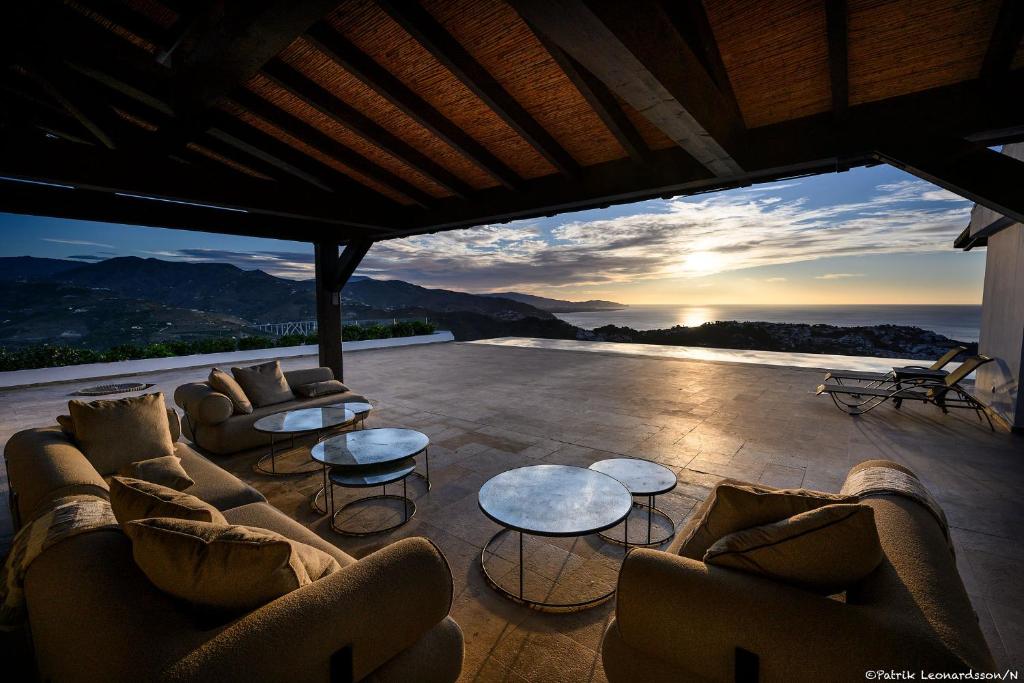 a living room with couches and tables and a sunset at Palacio de Cantalobos in Almuñécar