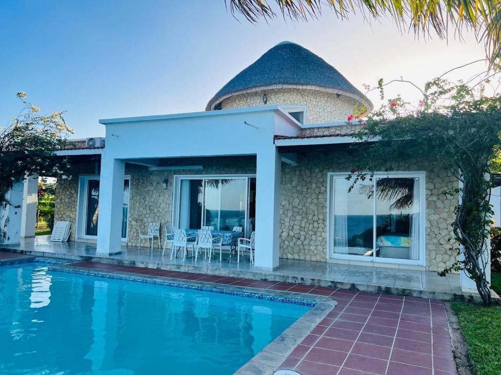 a house with a swimming pool in front of it at Paradise Beach House in Vilanculos