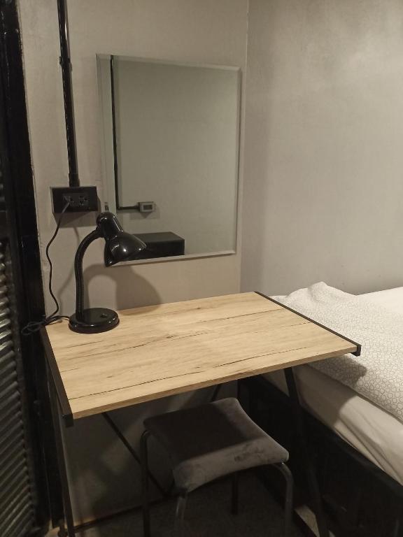 a desk with a lamp and a mirror in a room at Thesleeperhomestay in Ban Chuk Kum