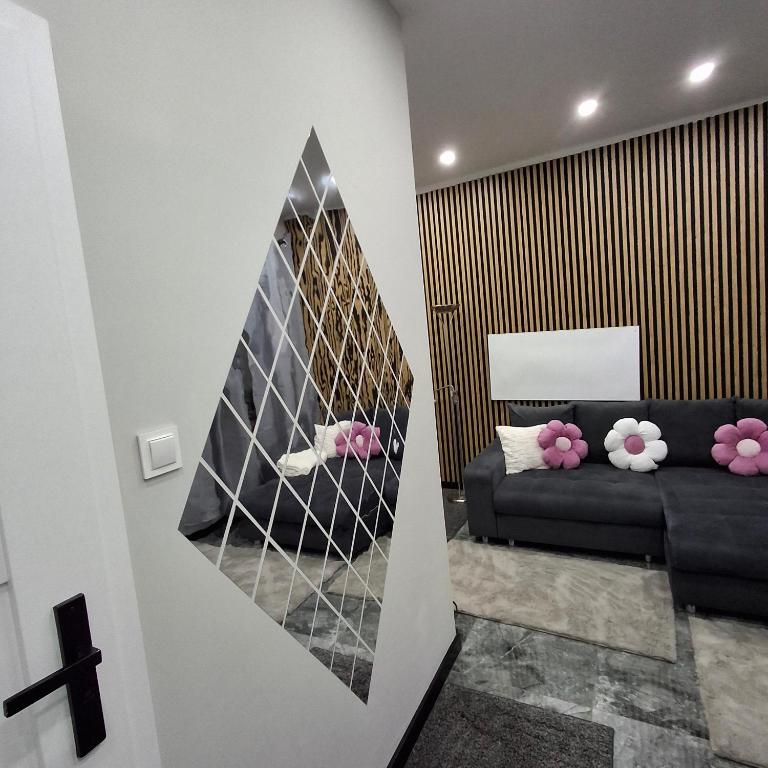 a living room with a black couch and a mirror at Studio Sudety osobne wejscie in Wałbrzych