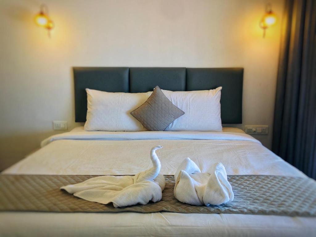 two swans sitting on top of a bed at The Coastal Agonda in Agonda