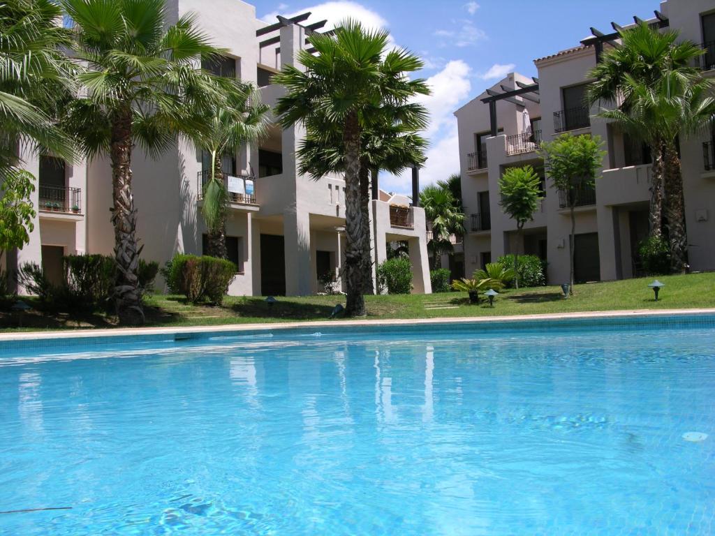 una piscina frente a algunos edificios de apartamentos en Roda Golf Resort 8007 - Resort Choice, en San Javier