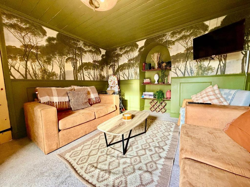a living room with a couch and a table at Style 3BR House Jameston | Garden | Near Tenby in Tenby