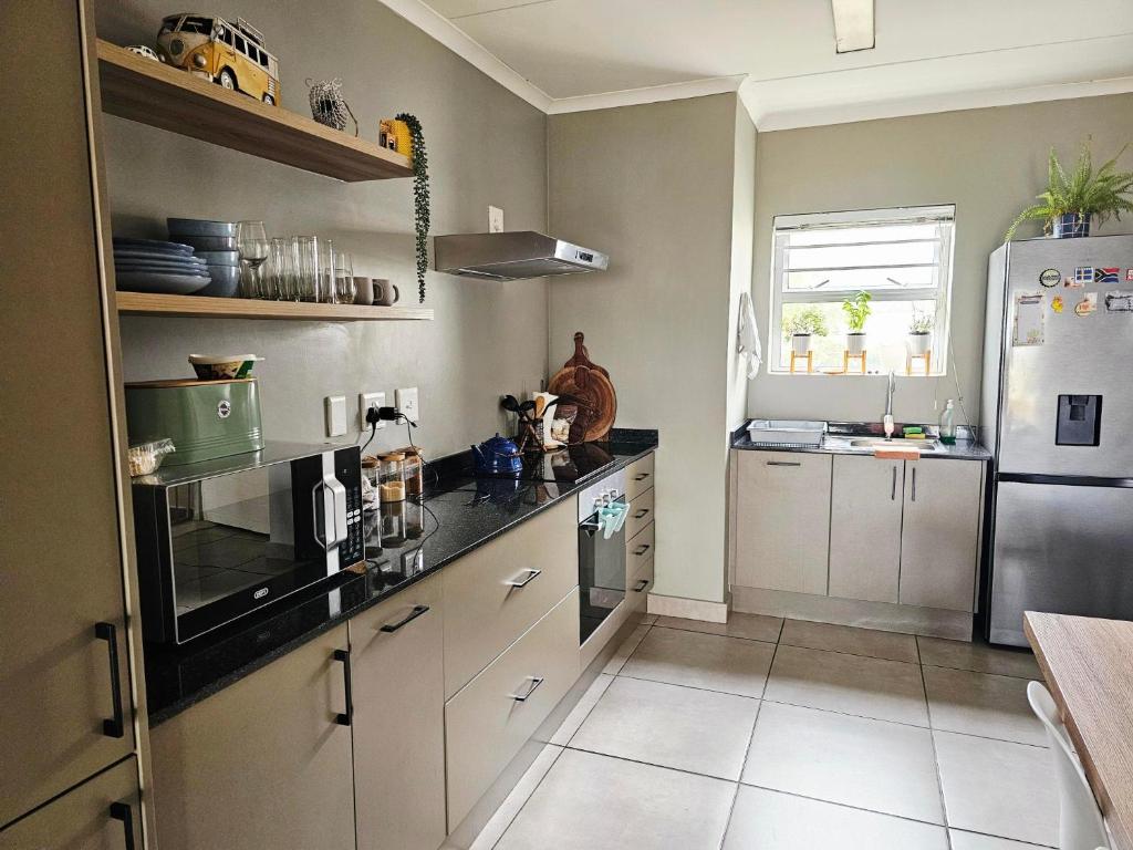 a kitchen with white cabinets and a refrigerator at Quarter 5, Two Zero Four in Oakdale