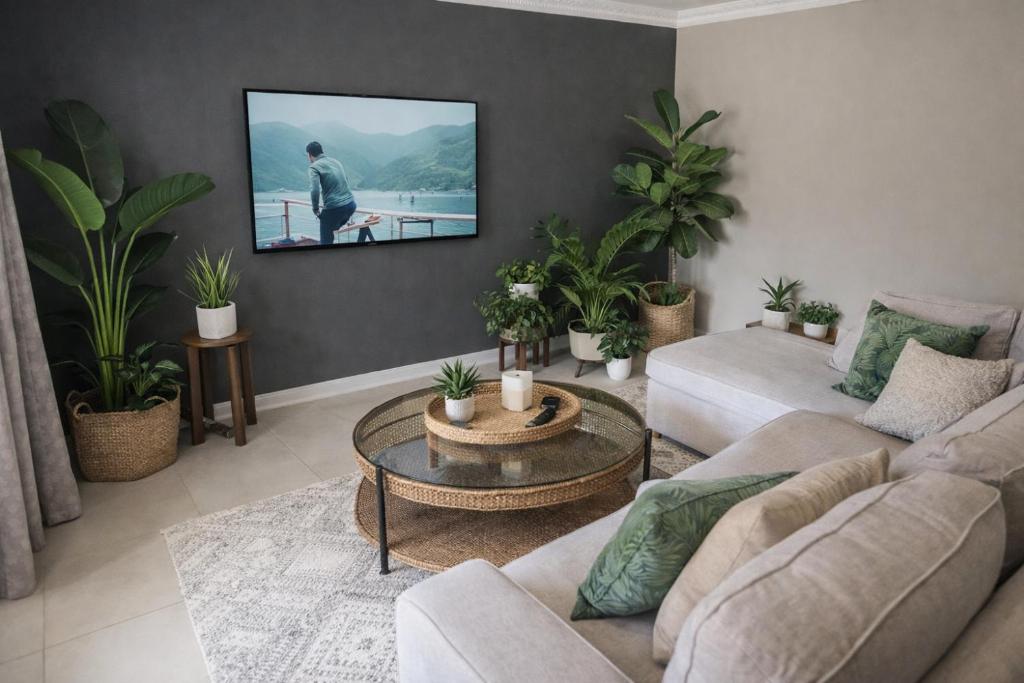 a living room with a couch and a tv on a wall at Gorgeous Garden Villa 3 in Gillitts-Emberton