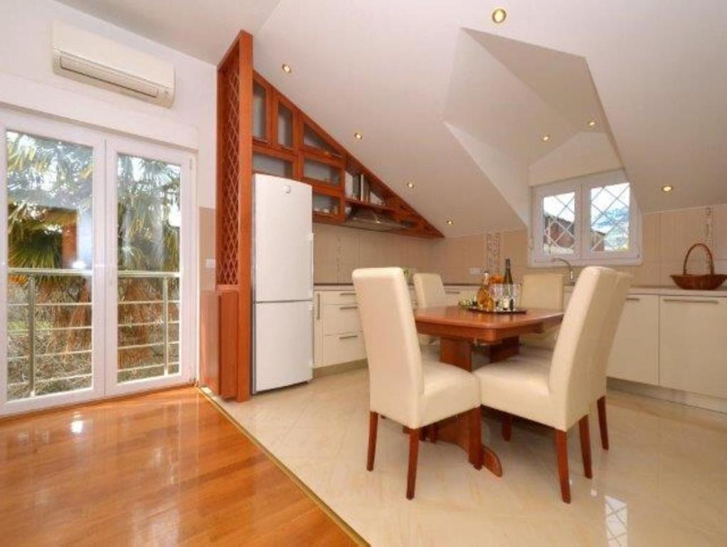 a kitchen with a wooden table and white appliances at Apartment Franka in Kaštela