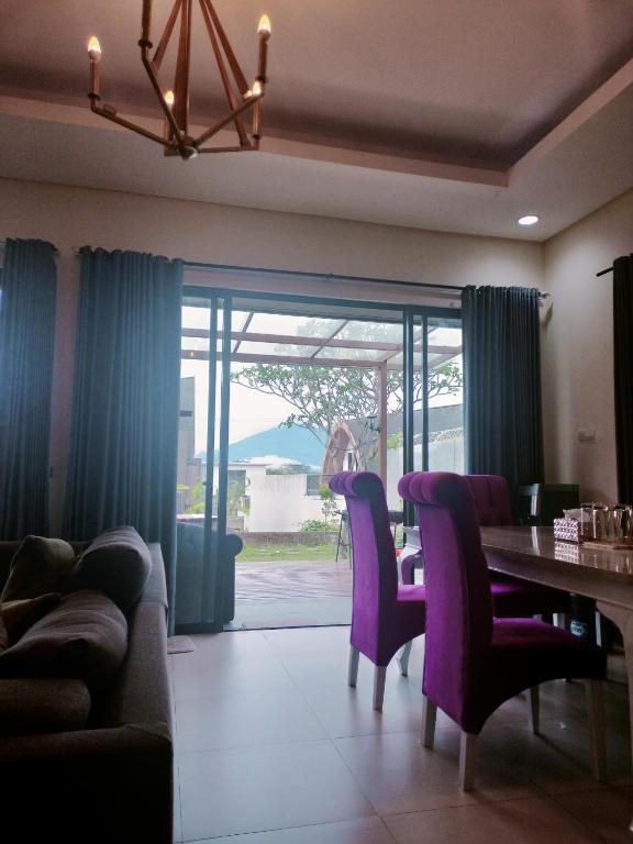 a dining room with a table and purple chairs at Vimalla Hills 2br Private pool, bebas Jam cekin, cekout sesuai jam cekin 24 jam,081tiga80satu6415satu in Gadok 1