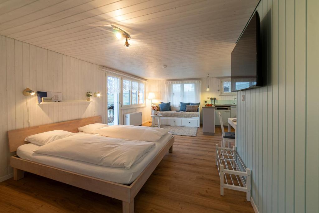 a bedroom with a bed and a living room at Studio Muerner in Wildhaus
