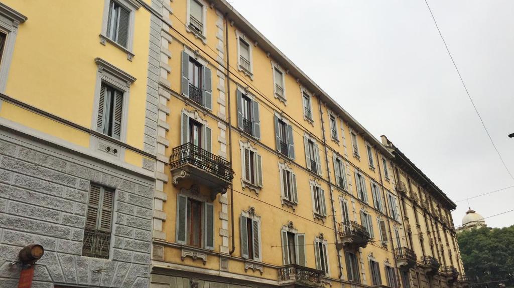 a large yellow building with balconies on the side of it at Hotel Arno in Milan