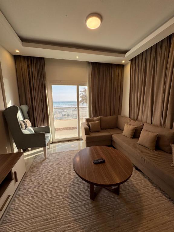 a living room with a couch and a table at Taqah Beach Front Apartment in Ţāqah