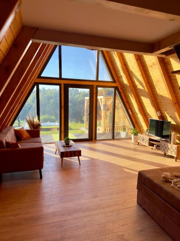 a living room with a roof with large windows at Harmony Cottage - Private Jacuzzi & Nature in Banja Luka