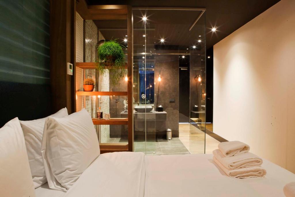 Un dormitorio con una cama blanca con toallas. en Manzo's Suites, en Zaandam