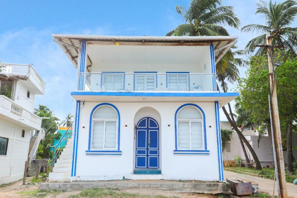 a blue and white house with palm trees at CASA Lasa Beach view in Kālapettai