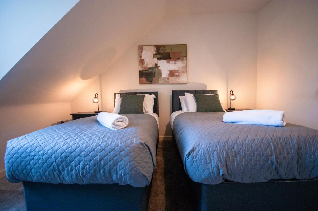two beds sitting next to each other in a room at Spacious Luxurious Serviced Accommodation 2 in Coventry