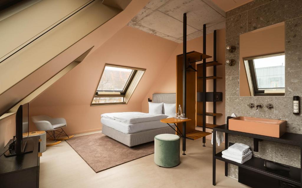 ein Schlafzimmer im Dachgeschoss mit Bett und Leiter in der Unterkunft Hotel Miano by Limehome in München