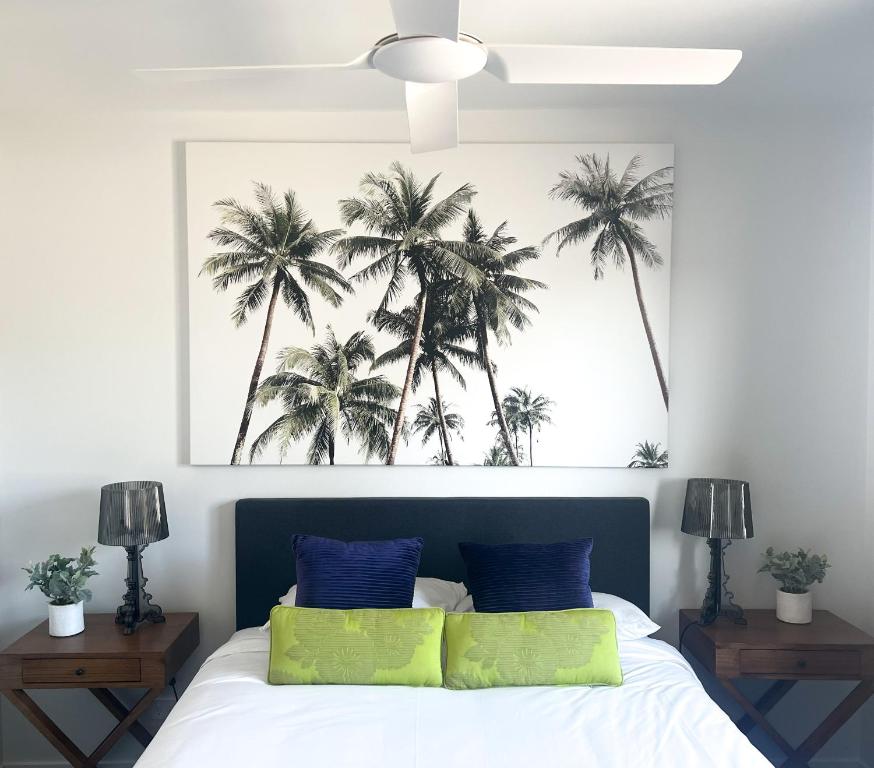 a bedroom with a bed with palm trees above it at Plantation Hotel Coffs Harbour in Coffs Harbour