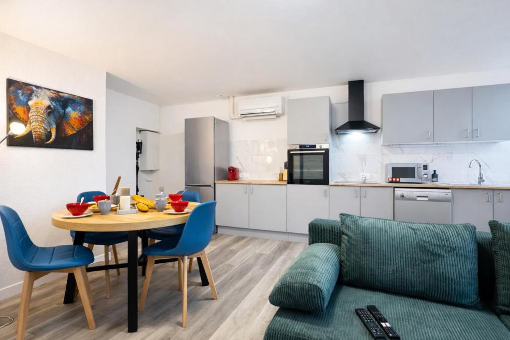 a kitchen and a living room with a table and a couch at Le Trilou - By BEST KEYS - Triplex Totalement Climatisé 3 Chambres - Lit King Size - Smart TV Canal Plus & Amazon Prime - Cuisine Équipée - Télétravail - Proche Centre & Canal de Bourgogne - Check-in Autonome in Brienon-sur-Armançon