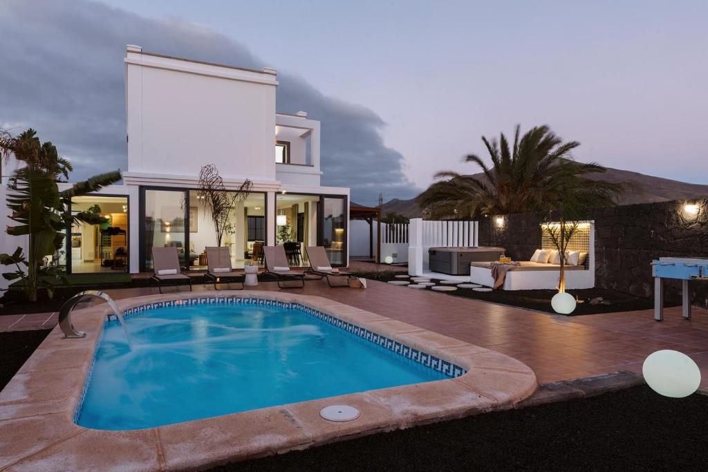 a villa with a swimming pool in front of a house at Villa Zendaya in Yaiza