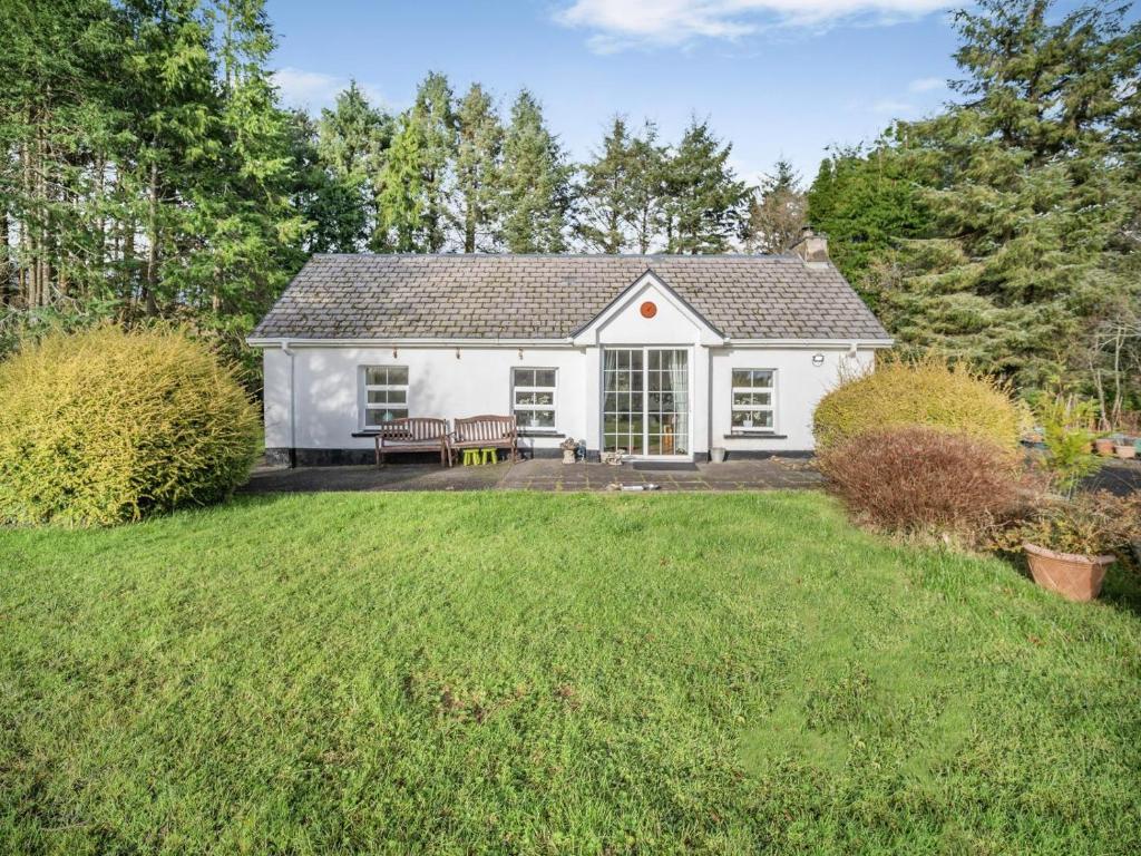 a white house with a bench in a yard at 2 Bed in Dunkineely oc-ii05062 in Dunkineely