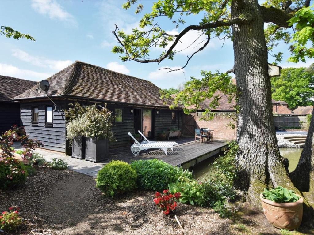 a house with a wooden deck and a tree at 1 Bed in Ashford oc-bt064 in Biddenden