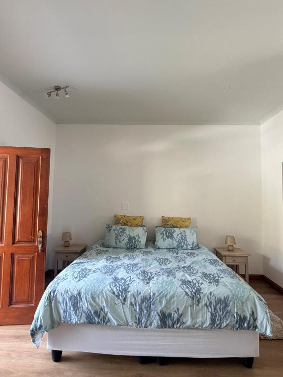 a bedroom with a bed with a blue comforter at Le Grec Wine Tram Apartment #2 in Franschhoek