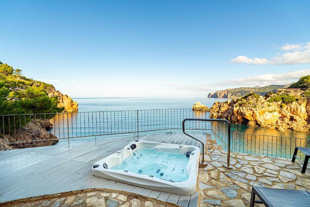 a hot tub sitting on a patio overlooking the ocean at Villa Ca La Dolors - Cala Deià, by PriorityVillas in Deia