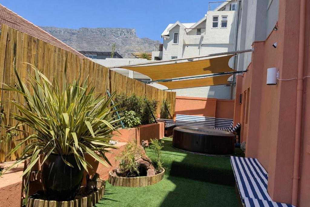 a courtyard with a fence and some plants and a fence at SweetStay - Kloof Street in Cape Town