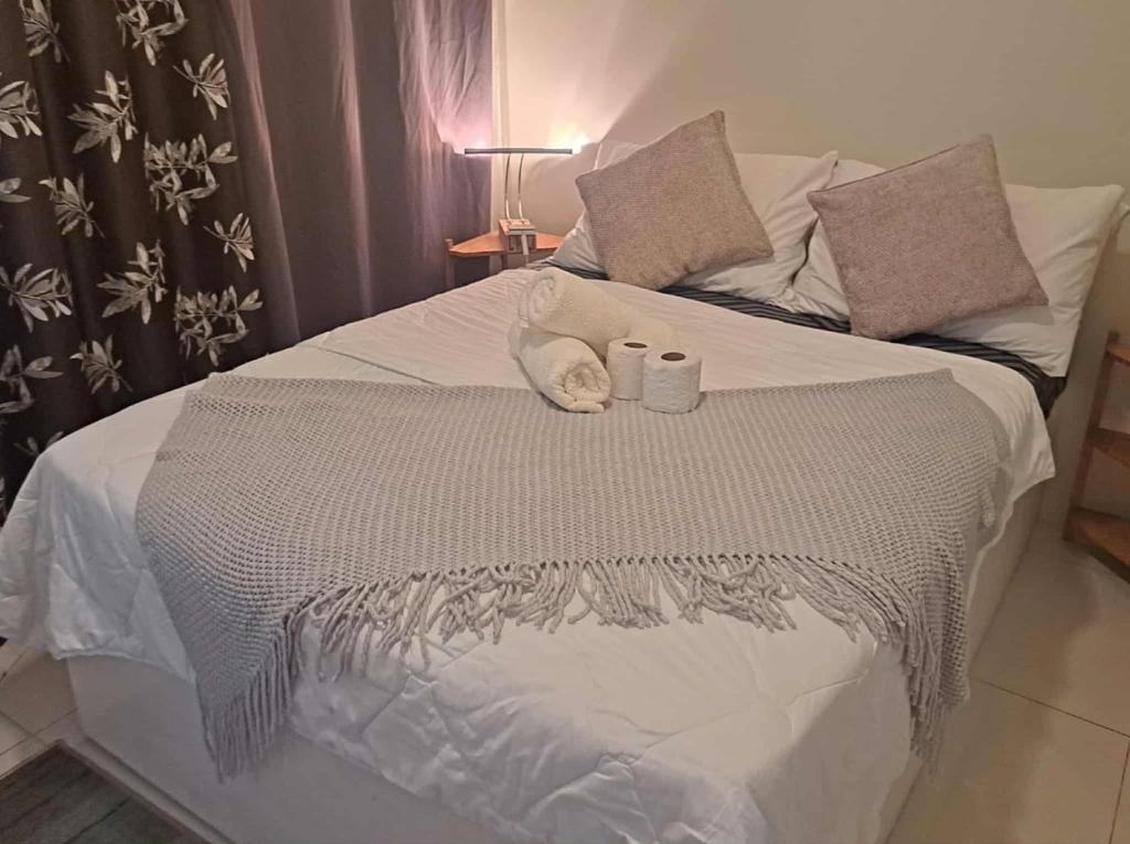 a bed with two pillows and two towels on it at Sandstone Unit Brenthill Condo in Baguio