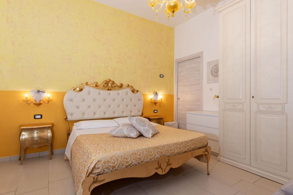 a bedroom with a large bed and a yellow wall at Martina B&B in Agropoli