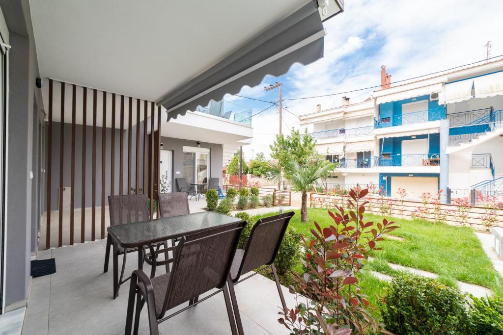a balcony with a table and chairs and a yard at Perla Stay Complex by Horizon Homes in Ofrínion