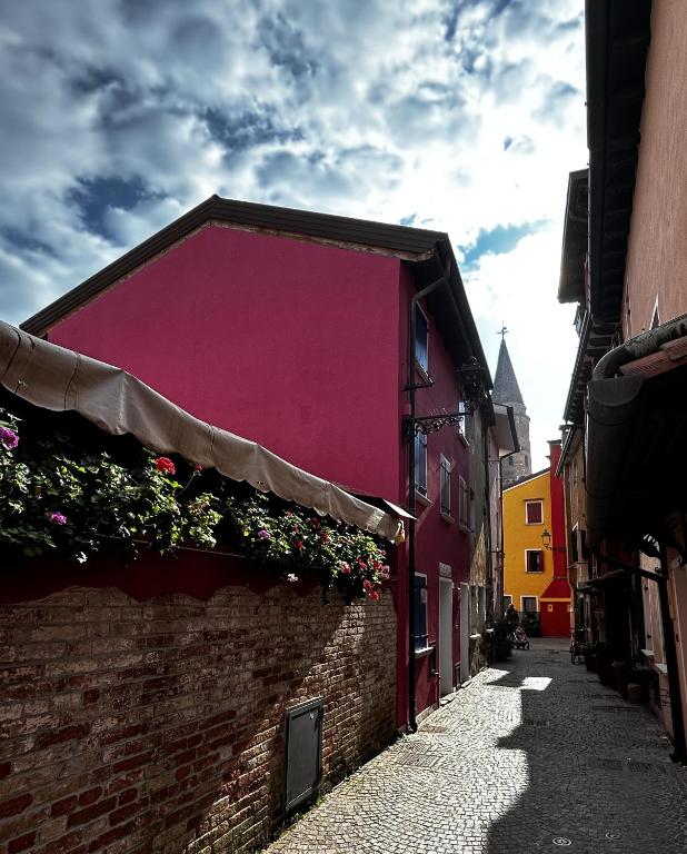 a pink building with flowers on the side of a street at Ca' Del Doge in Caorle