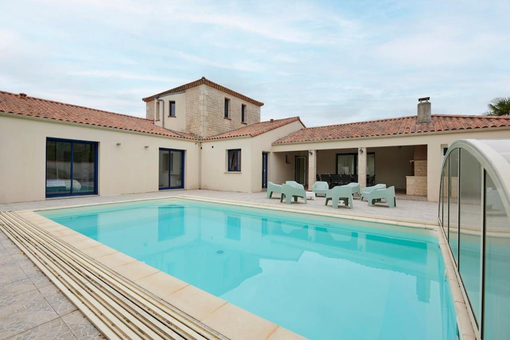 a pool in the backyard of a house at Tour Maréchal - Villa d'Exception in LʼHerbergement