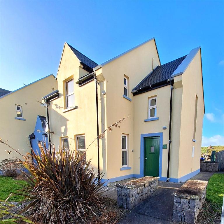 a large white house with a green door at Doolin Court in Doolin