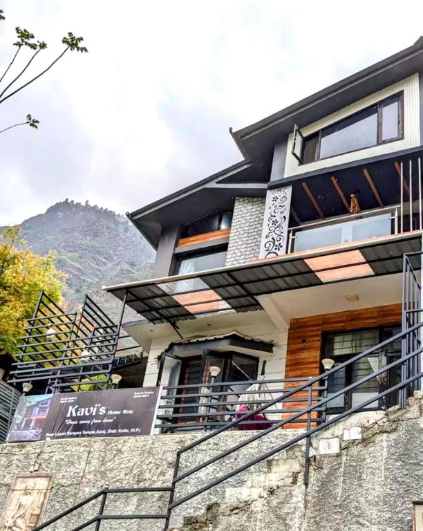 a building with a mountain in the background at Kavi's Vacation Homes - Peaceful stay in sainj valley in Sainj
