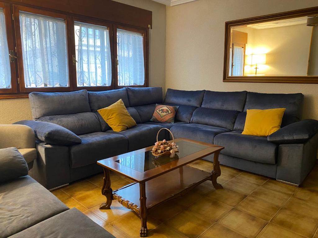 a living room with a blue couch and a coffee table at Los Henares 3 in Olombrada
