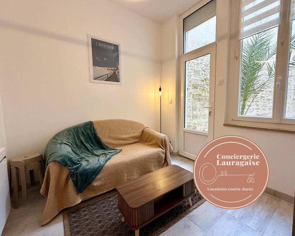 a bedroom with a bed and a table and a window at L'Atrium - Cour intérieure & box vélo, rdc in Castelnaudary