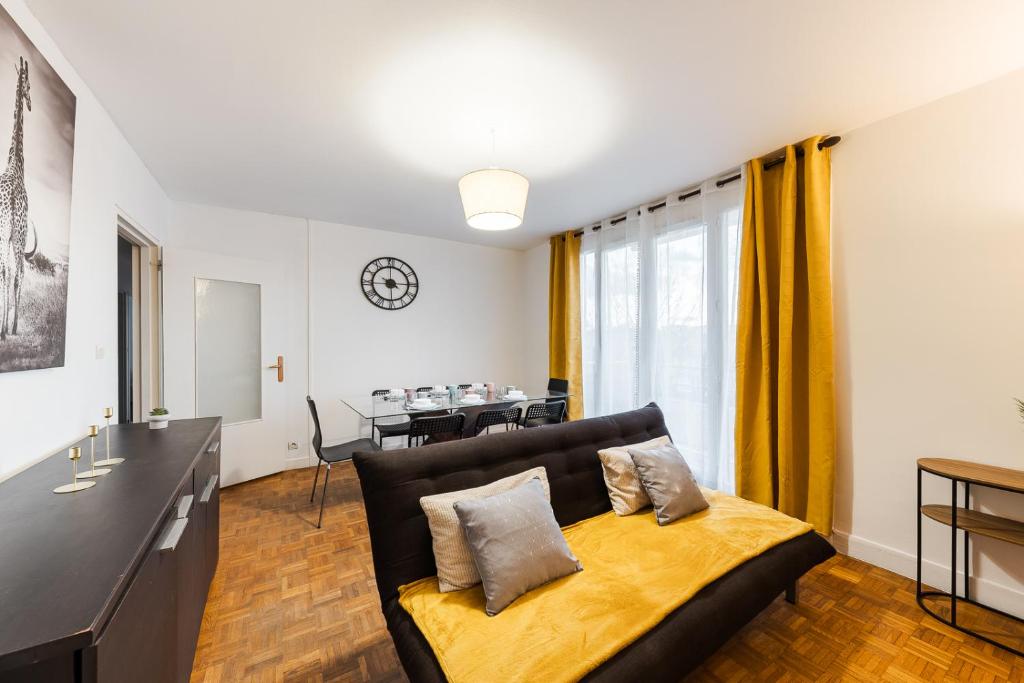 a living room with a couch and a table at L'Horizon in Noisy-le-Grand