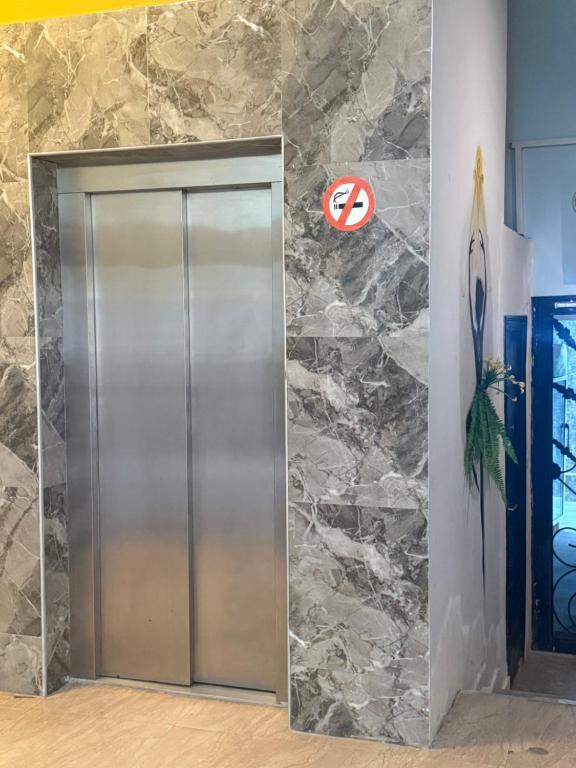 an elevator in a lobby with a stone wall at у моря in Itʼkhvisi