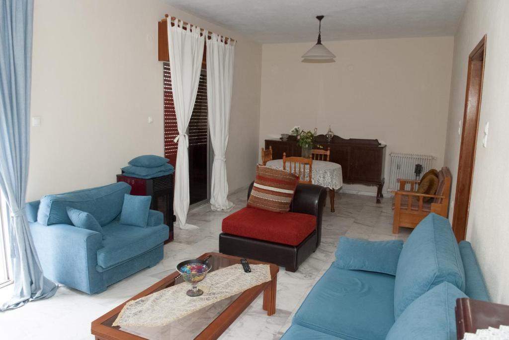 ein Wohnzimmer mit Sofas, Stühlen und einem Tisch in der Unterkunft Meteora Christian's Place in Tríkala