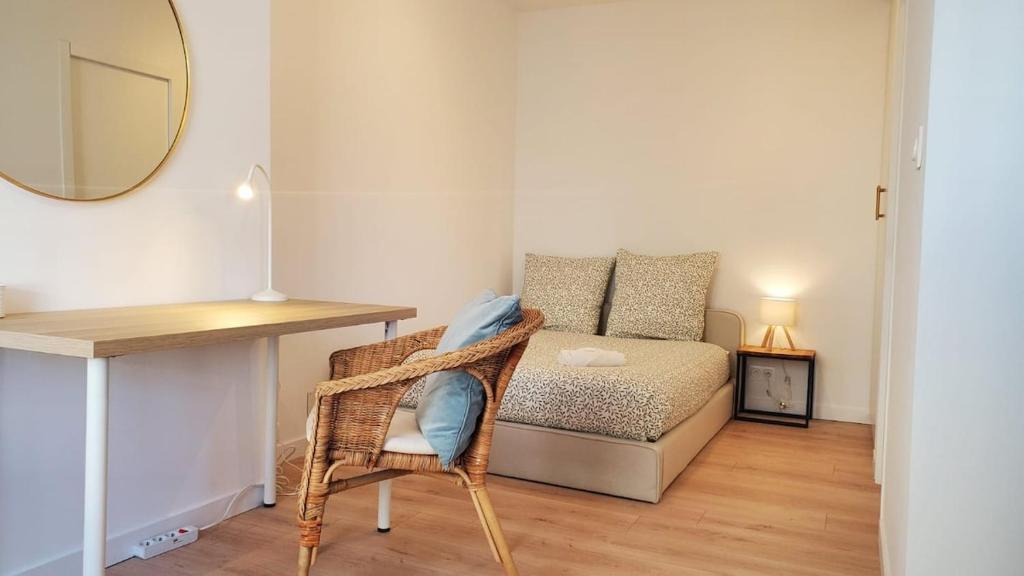 a room with a desk and a bed with a mirror at Le Balcon Cosy - Centre Clermont in Clermont-Ferrand