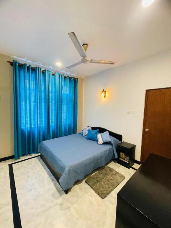a bedroom with a bed and a ceiling fan at SAN Holiday Villa in Wadduwa