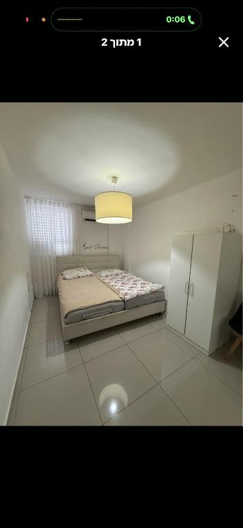 a small bedroom with a bed and a light at Luba in H̱olon