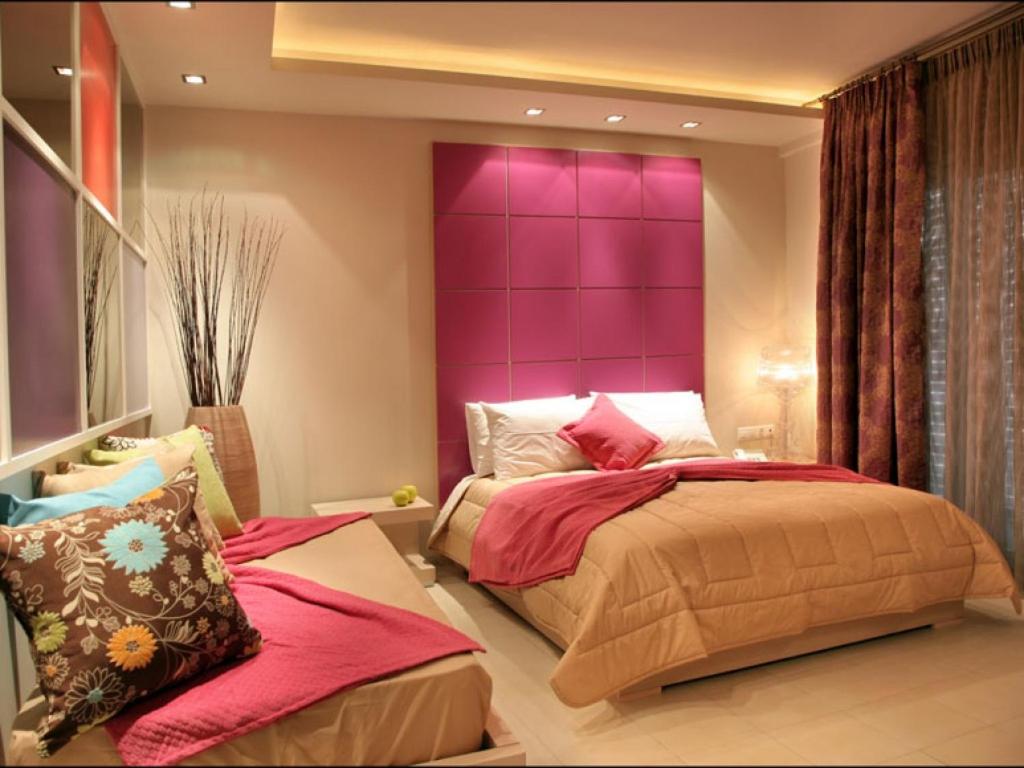 a bedroom with a purple headboard and two beds at Hotel Panorama in Koukounaries