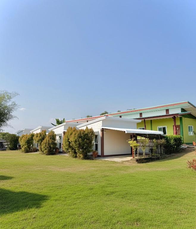 a house with a green lawn in front of it at Queue&Bright Resort in Ban Pa Tung (7)