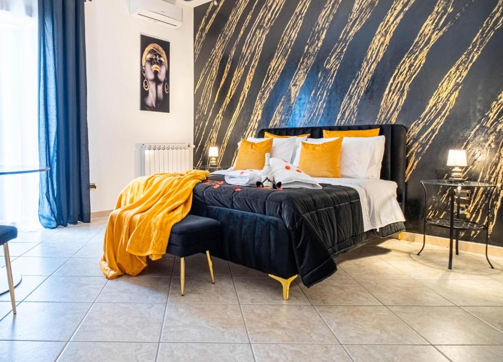 a bedroom with a bed with a yellow blanket on it at Suite del Corso in Ficarazzi