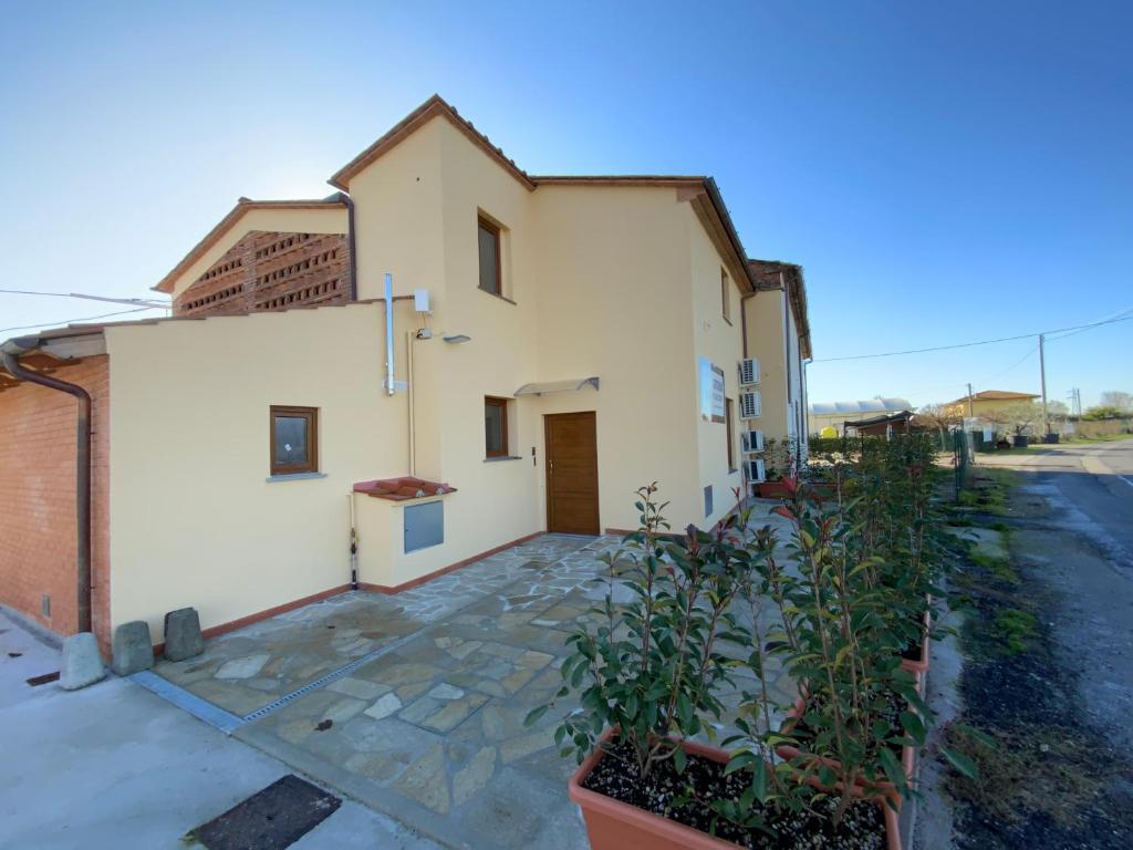 a white house with a driveway and some plants at Casale La Rosa Azzurra in Ponte Buggianese