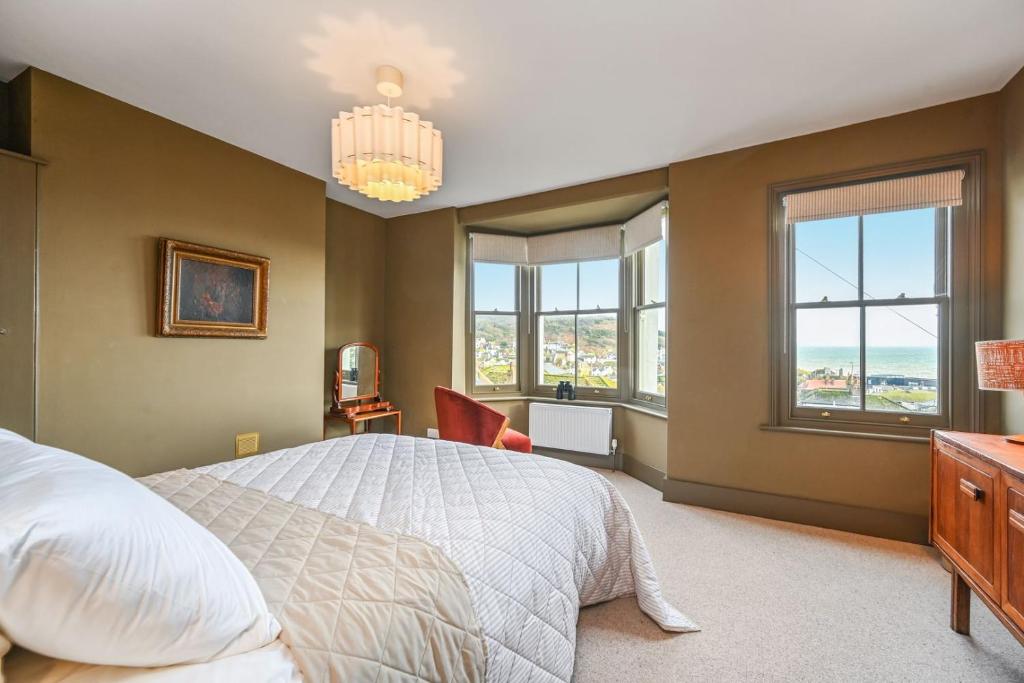 a bedroom with a bed and a desk and windows at Hastings View in Hastings