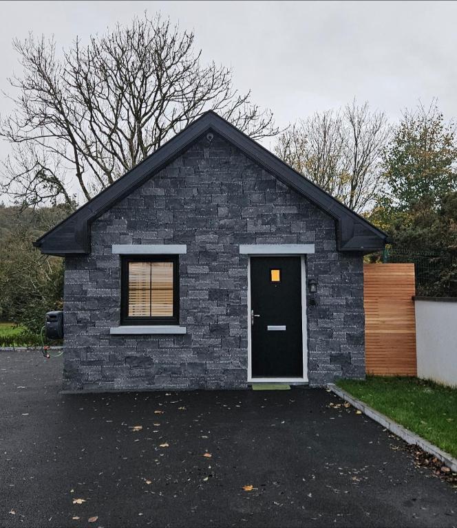 a small brick house with a black door at Sullane Weirs in Macroom