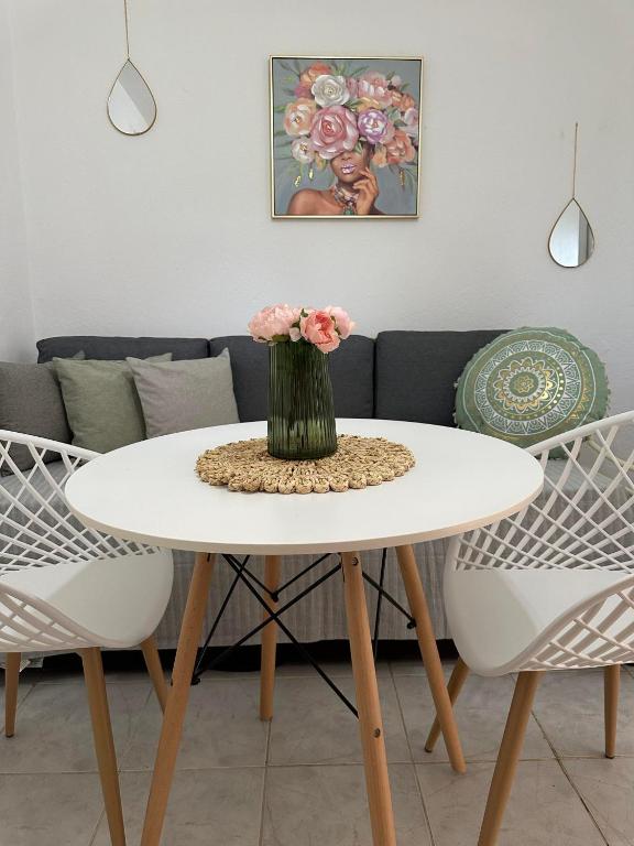 a white table with a vase of flowers on it at SO SIMPLE mouresi in Mouresi