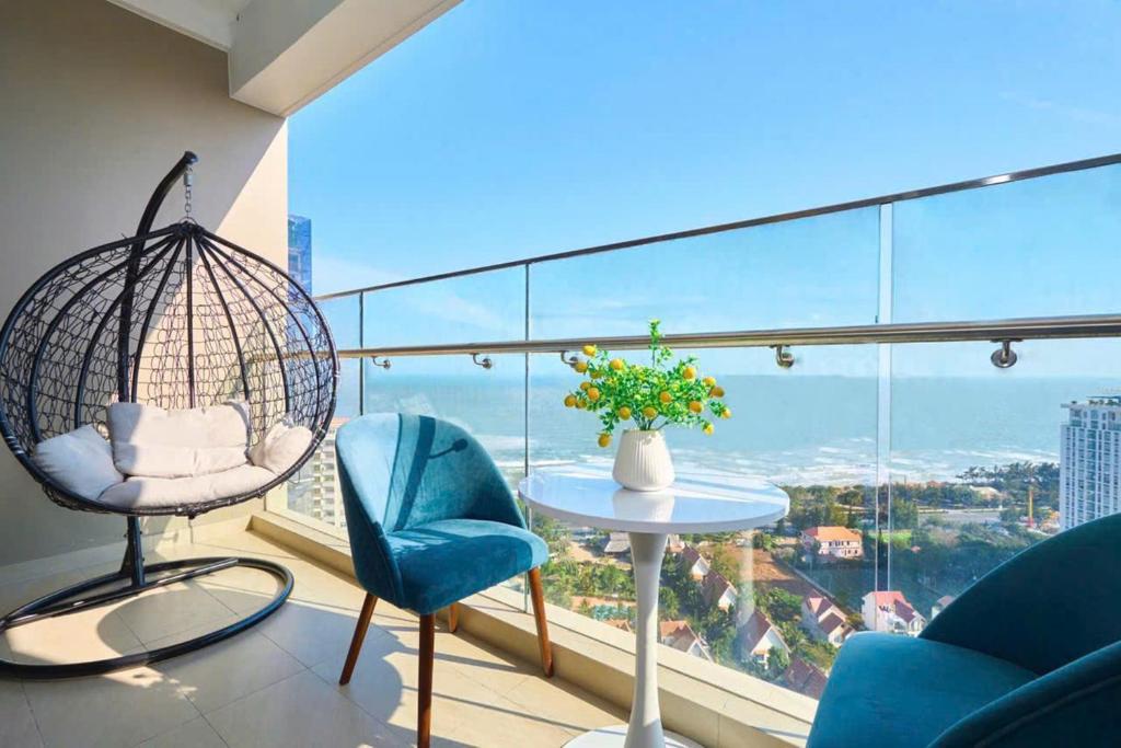 a room with a balcony with a table and chairs at The Sóng Vung Tau Apartment - Pool Near Sea in Vung Tau